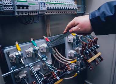 Elektrik kutusuna anahtarları test elektrikçiler eller. Sigortalar ve Kontaktörler elektrik paneli.