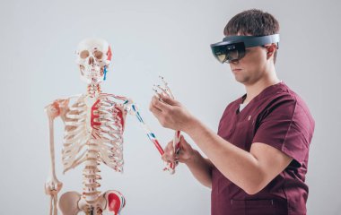 Doktor insan iskeletini incelemek için artırılmış gerçeklik gözlüğü kullanıyor.