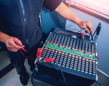 Elecric motorlu pilleri şarj. Pil bir elektrikli araç motorunun sökülmesi. Araba Servisi