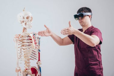 Doktor insan iskeletini incelemek için artırılmış gerçeklik gözlüğü kullanıyor.