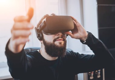 Sanal gerçeklik giyen genç adam ofiste gözlükler.