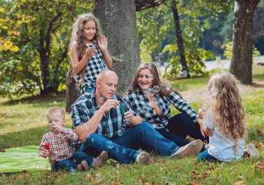 Büyük genç aile parkta iyi vakit geçiriyor.