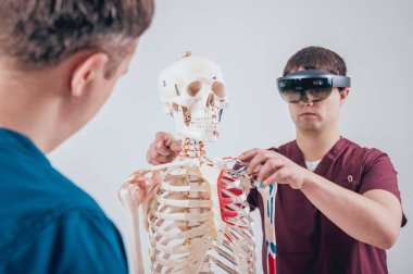 Doktor kullanır augmented gerçeklik gözlükleri ve öğrenci öğretim insan iskeleti