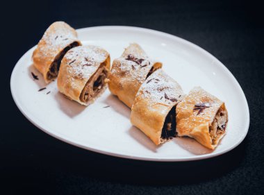 Çikolata karanlık yüzeyi beyaz tabakta strudel closeup süslenmiş