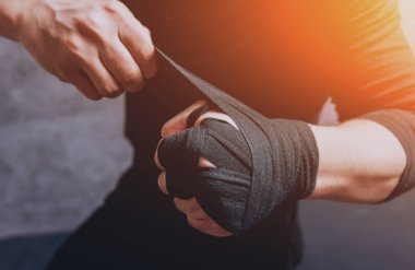 Bir sokak savaşçısı elastik bandaj ellerini koyar.