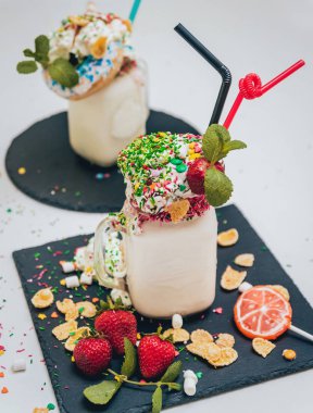İle sprinkles, çilekli milkshake bardak çırpılmış krema ve taze çilek