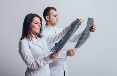 Doktorlar hastanın daha önce beyaz duvar MRI tarama dikkatle inceliyor