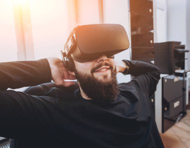 Sanal gerçeklik giyen genç adam ofiste gözlükler.