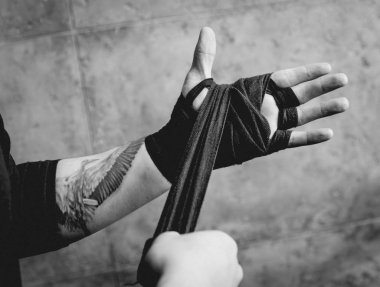 Bir sokak savaşçısı elastik bandaj ellerini koyar.