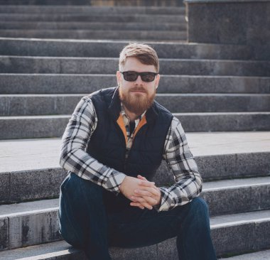 Yakışıklı adam açık havada kameraya poz rahat kıyafetler içinde sakallı