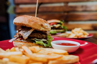 Büyük çizburger ve patates kızartması bir plaka üzerinde. Restoran