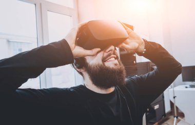 Sanal gerçeklik giyen sakallı genç adam ofiste gözlükler