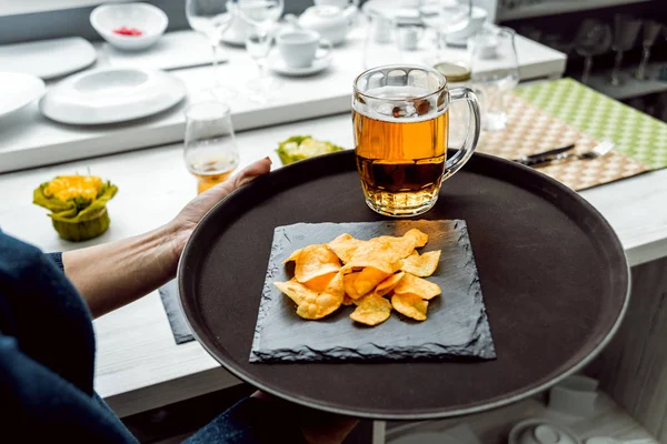 Beer and chips on the large dish. Restaurant