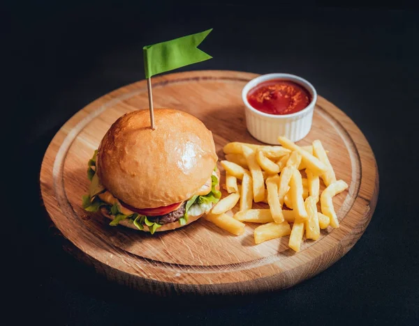 Yangınlar ahşap tahta üzerinde büyük ve lezzetli burger.