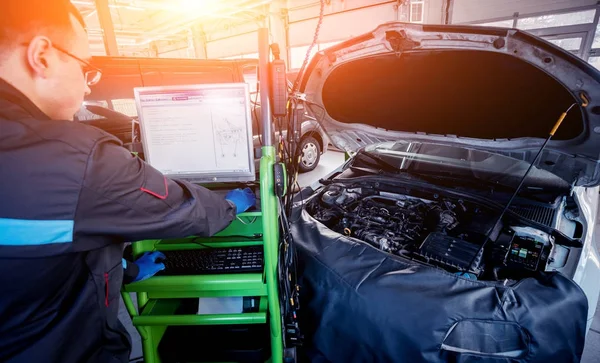 Mecánico profesional de automóviles que trabaja en el servicio de reparación de automóviles. — Foto de Stock