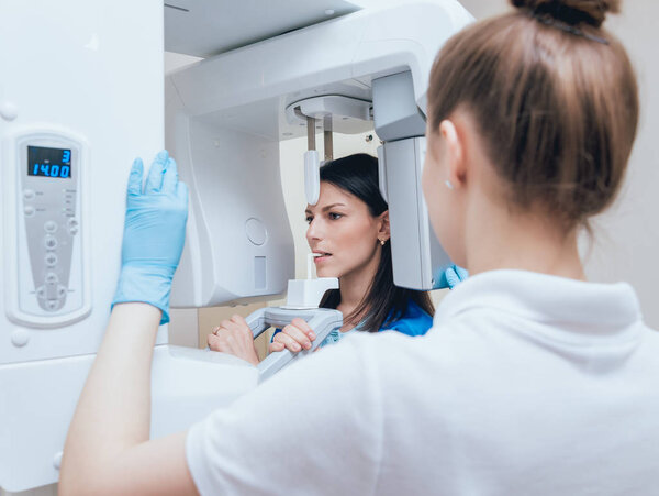 Young woman patient standing in x-ray machine. Panoramic radiography