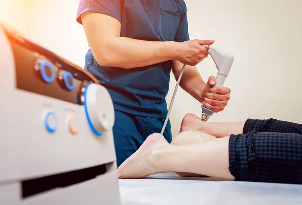 Shock wave therapy. The magnetic field, rehabilitation. Physiotherapist doctor performs surgery on a patient's heel — Stock Image Shock Wave Therapy Magnetic Field Rehabilitation Physiotherapist Doctor Performs Surgery Royalty Free Stock Photos