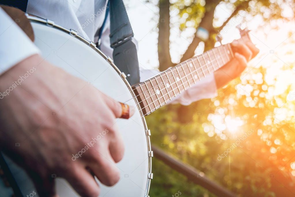 Cropped image of musician playing banjo at the street