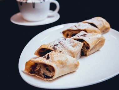 Çikolata karanlık yüzeyi beyaz tabakta strudel closeup süslenmiş
