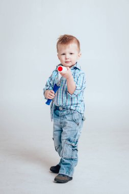 Silindir beyaz arka plan üzerinde olan küçük çocuk. İnşaat, onarım, İçişleri.