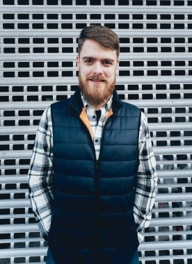 Yakışıklı adam açık havada kameraya poz rahat kıyafetler içinde sakallı