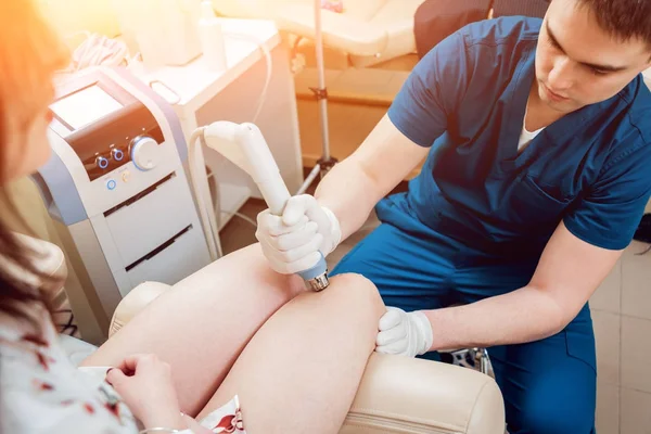 Shock wave therapy. The magnetic field, rehabilitation. Physiotherapist doctor performs surgery on a patient's knee — Stock Image Shock Wave Therapy Magnetic Field Rehabilitation Physiotherapist Doctor Performs Surgery Stock Photo