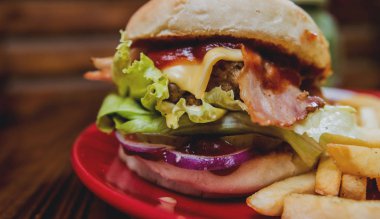 Büyük çizburger ve patates kızartması bir plaka üzerinde. Restoran