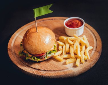 Yangınlar ahşap tahta üzerinde büyük ve lezzetli burger.