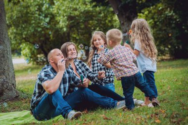 Büyük genç aile parkta iyi vakit geçiriyor.