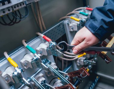 Elektrik kutusuna anahtarları test elektrikçiler eller. Sigortalar ve Kontaktörler elektrik paneli.