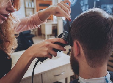 Kuaför saç modeli için genç bir adam yapar..