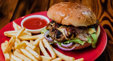 Büyük çizburger ve patates kızartması bir plaka üzerinde. Restoran