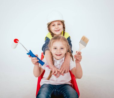 Onarım veya inşaat beyaz üzerinde oynarken örgüler ile iki küçük neşeli kız