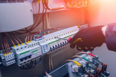 Elektrik kutusuna anahtarları test elektrikçiler eller. Sigortalar ve Kontaktörler elektrik paneli.