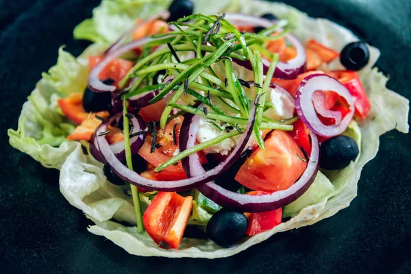 Lahana, zeytin ve mozzarella peyniri siyah plaka üzerinde Yunan salatası