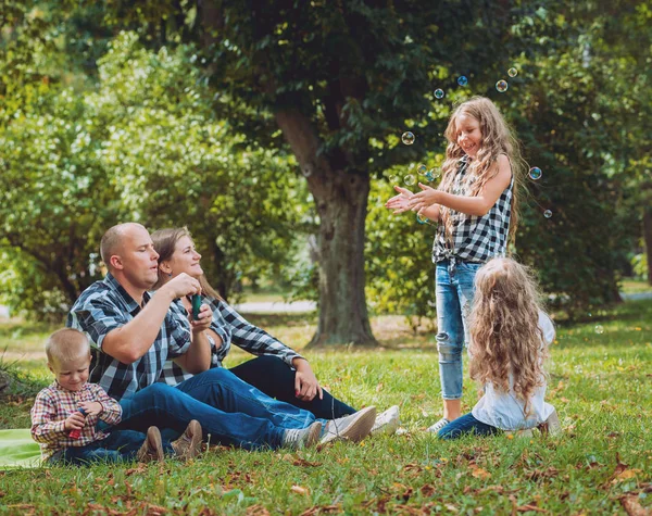 Νεαρή Οικογένεια Και Χαρούμενα Παιδιά Φούσκα Φυσητήρες Στο Πάρκο — Φωτογραφία Αρχείου