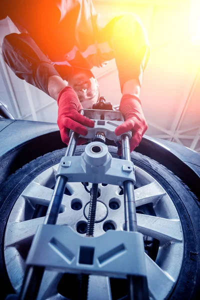 Araba tamircisi sensör süspansiyon ayarı sırasında yükleme. Tekerlek hizalama iş yerinde onarım servis istasyonu