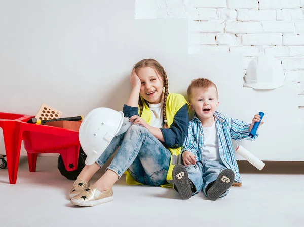 Örgüler ve onarım veya inşaat oynayan erkek kardeşi ile küçük kız
