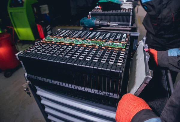 Elecric motorlu pilleri şarj. Pil bir elektrikli araç motorunun sökülmesi. Araba Servisi