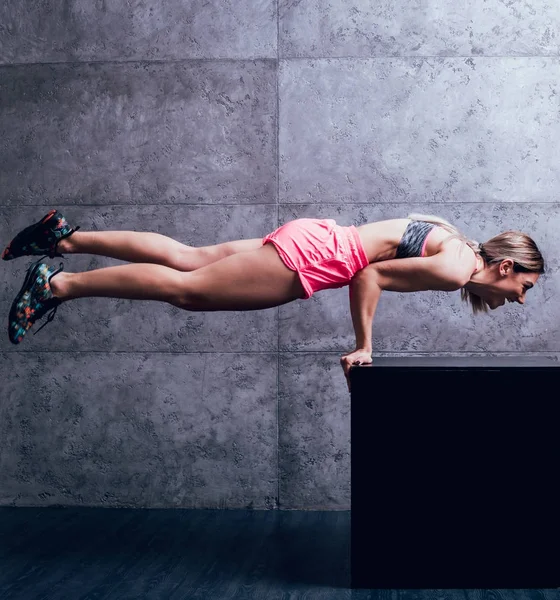 Studio poz ve farklı egzersizleri yapıyor genç atletik beyaz kadın.