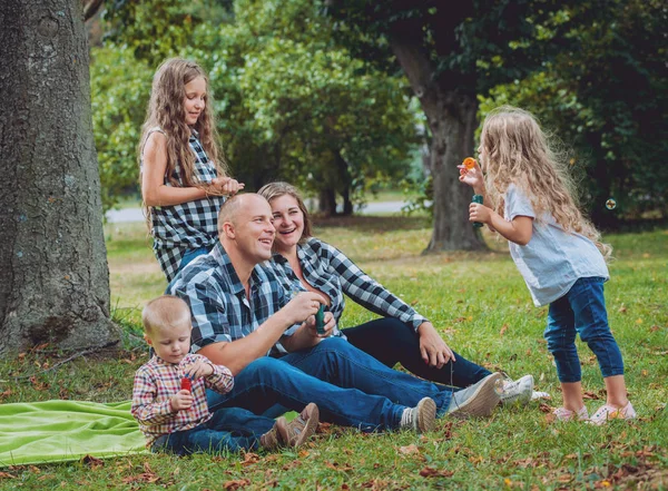 Büyük genç aile parkta iyi vakit geçiriyor.
