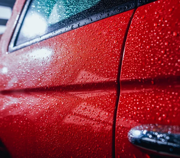 Elektrikli otomobil ayrıntıları. Kapı kolu ve yağmur damlaları. Kırmızı renk