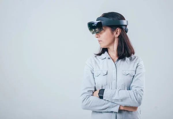 Woman wearing augmented reality goggles, isolated on white