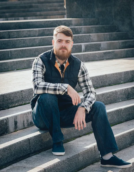 Yakışıklı adam açık havada kameraya poz rahat kıyafetler içinde sakallı