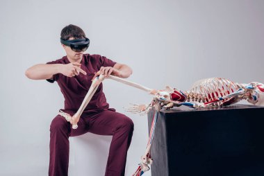 Doktor insan iskeletini incelemek için artırılmış gerçeklik gözlüğü kullanıyor.