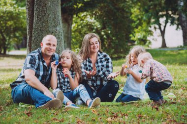 Büyük genç aile parkta iyi vakit geçiriyor.