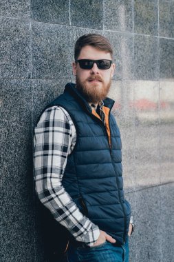 Yakışıklı adam açık havada kameraya poz rahat kıyafetler içinde sakallı