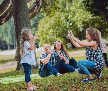 Büyük genç aile parkta iyi vakit geçiriyor.