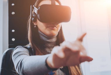 Sanal gerçeklik giyen genç ve güzel kız ofiste gözlükler