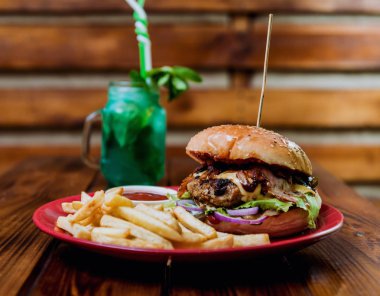 Büyük çizburger ve patates kızartması bir plaka üzerinde. Restoran